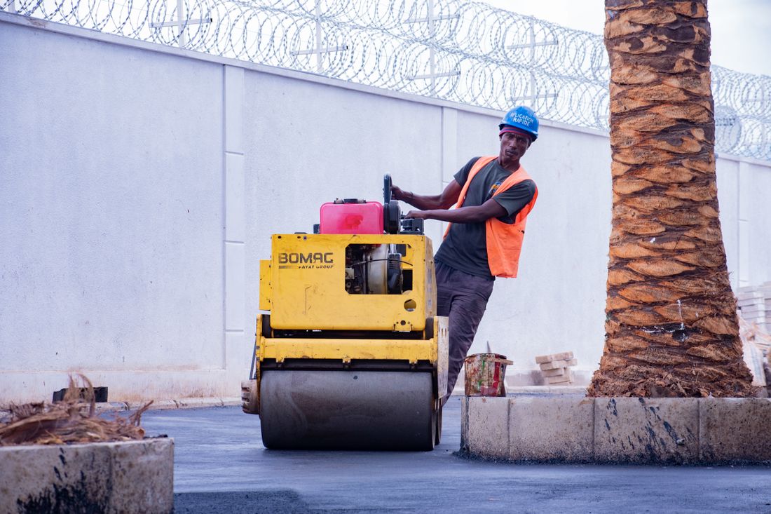 Road construction equipment laying and compacting an asphalt surface